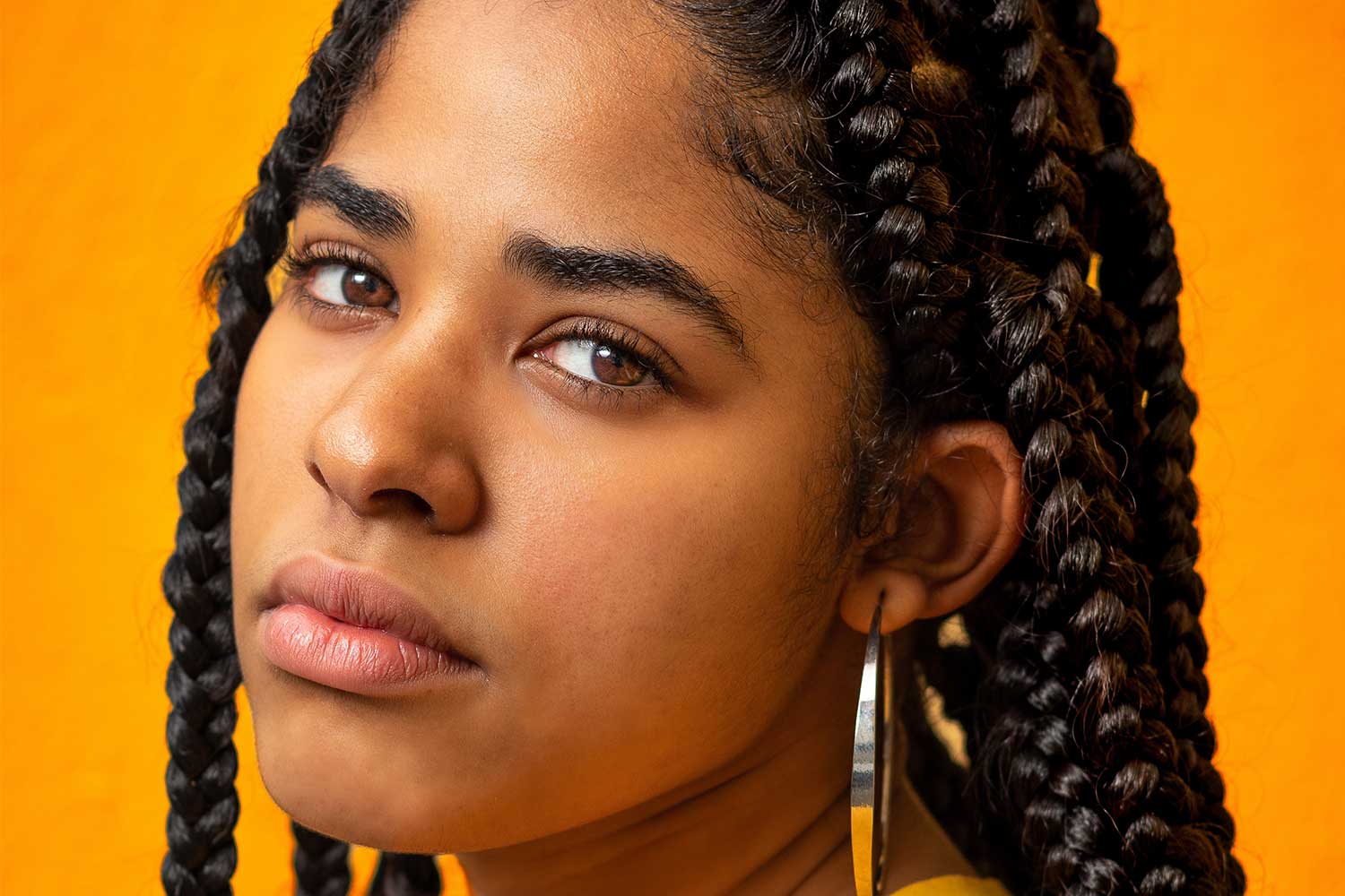 woman with tight braided hair looking to find relief from the pain