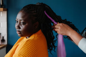 woman getting hair braided, wondering how long do african braids last