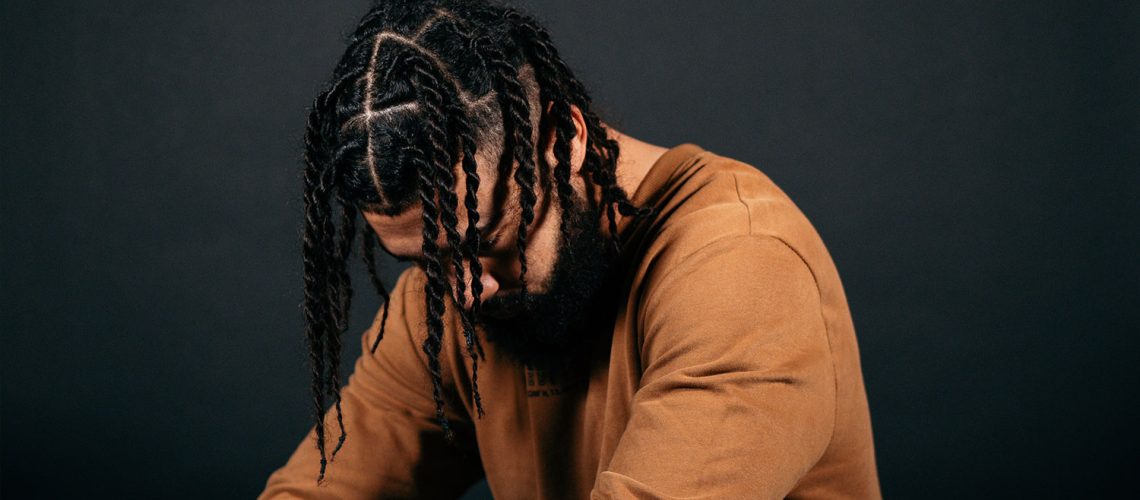 man pondering do braids help grow hair