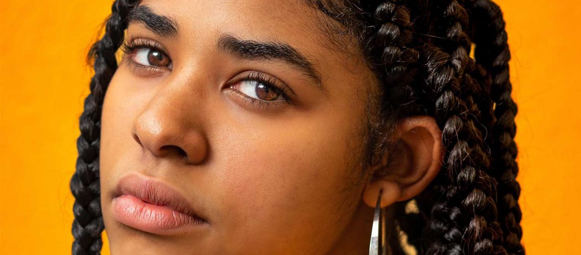 woman with tight braided hair looking to find relief from the pain